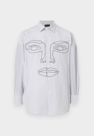 Světle šedá košile s dlouhým rukávem a zapínáním na knoflíky vpředu, s černým obrysem obličeje přes hrudník a svislými pruhy.