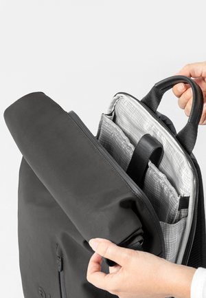 Schwarzer Rucksack mit glatter Außenfläche und strukturierter grauer Innenauskleidung. Verfügt über einen oberen Griff und organisierte Innenfächer.