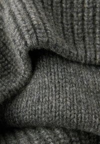 Ciemnoszara dzianina prążkowana o miękkiej, puszystej fakturze z wyraźnymi pionowymi liniami i grubym, ciepłym wyglądem.