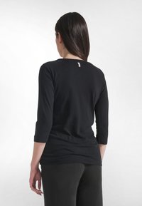 Czarna dopasowana bluzka z długimi rękawami do połowy przedramienia i zaokrąglonym dekoltem. Gładka, elastyczna tkanina z minimalnymi przeszyciami.