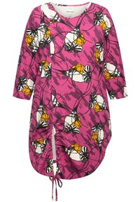 Túnica de color rosa brillante con estampado floral en blanco y amarillo. Presenta un escote redondo, mangas tres cuartos y fruncidos laterales con lazos.