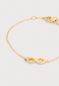 Βραχιόλι με αλυσίδα από χρυσό, με μενταγιόν σε σχήμα σύμβολο του άπειρου διακοσμημένο με λαμπερούς στρας και κούμπωμα με κλιπ αστακού.