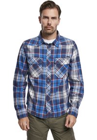 Gestreepte flanellen shirt met knopen in een blauw-wit ruitpatroon met rode accenten. Beschikt over twee borstzakken en een spitse kraag.