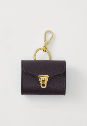 Porte-clés en cuir violet avec une finition texturée, quincaillerie dorée, un fermoir et un détail de porte-clés arrondi en haut.