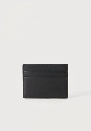Porte-cartes en cuir noir avec trois emplacements pour cartes et logo GANT discrètement embossé à l'avant sur fond blanc.