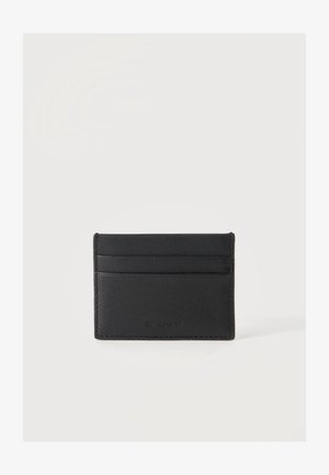 Tarjetero de cuero negro con tres ranuras para tarjetas y logo sutil de GANT en relieve en el frente sobre un fondo blanco.