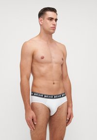 Boxeri albi din bumbac, cu un elastic negru la talie, inscripționat cu brandul "just cavalli". Boxerii au o croială tradițională și o textură netedă.