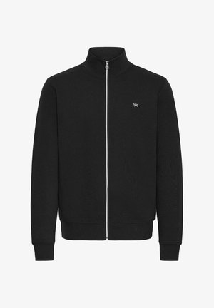 Svart zip-up jakke i en glatt bomullsblanding. Har høy krage og subtil logo på venstre bryst. Lange ermer med ribbestrikkede mansjetter.