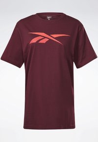 Camiseta de algodón color burdeos con un gráfico del logo de Reebok en rojo. Tiene un escote redondo, mangas cortas y un corte relajado.