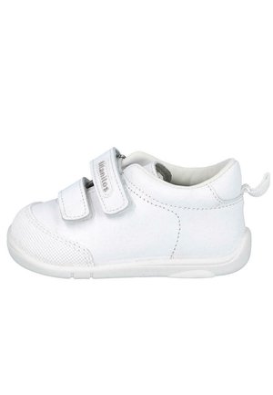 Zapatilla blanca con dos correas de velcro, parte superior de sintético liso, puntera texturizada y suela de goma. Forma redondeada con una pestaña en la parte posterior.