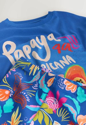 Tricou albastru cu textul „Papaya” și imprimeu colorat cu fructe tropicale și flori suprapus pe tricou.