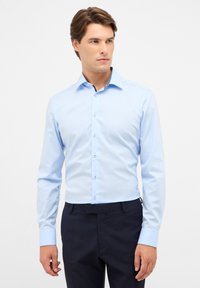 Camicia azzurro chiaro a maniche lunghe con colletto a punta, bottoni bianchi e dettagli a fantasia all'interno del colletto. Tessuto liscio con taglio aderente.