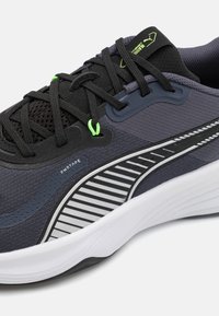 Adidași sport de culoare gri închis, cu plasă neagră și inserții sintetice, având accente în dungi alb-negru, detalii verzi și talpă texturată.