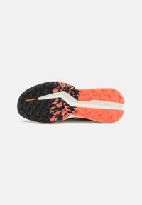 Suela de zapatilla de correr negra y naranja con un patrón texturizado, que presenta una میڈیا blanca y un logo de Continental en la suela.