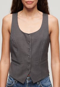 Grijze gestreepte vest met een ronde halslijn, zes knopen aan de voorkant en twee zijzakken. De stof heeft een gladde textuur en een getailleerd ontwerp.