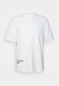 Biały bawełniany t-shirt z krótkimi rękawami, okrągłym dekoltem oraz logo "Calvin Klein Jeans" w kolorze granatowym na dolnym lewym rogu.