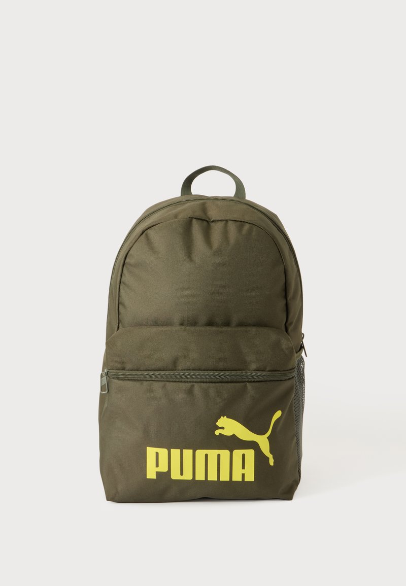 Sac à dos vert Puma avec logo jaune sur la poche avant et la poignée supérieure sur fond clair uni.