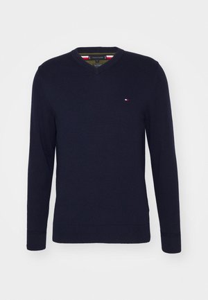 Marineblauer V-Ausschnitt Langarmpullover mit kleinem Tommy Hilfiger-Logo auf der Brust und gerippten Bündchen und Saum.