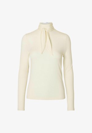 Pika pikkade varrukatega kreemjas ülemus kõrge kaelusega ja lipsu detailiga krael, valmistatud pehmest kangast sujuva tekstuuri jaoks.