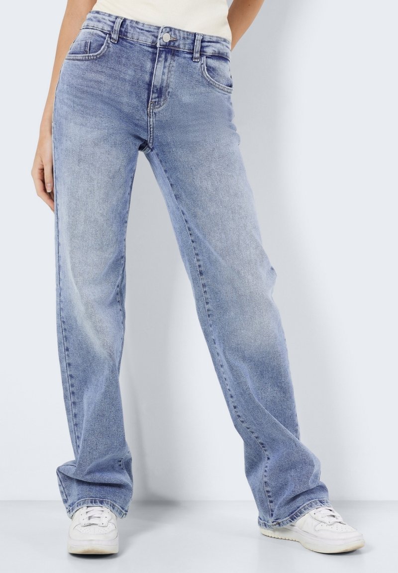 Ljust blå, högmidjade denimjeans med lös passform, som har framfickor, bältesöglor och blekningsdetaljer. Bärs med vita sneakers.