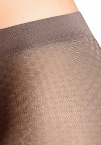 Leggings texturés marron clair en matière de coton doux avec une large taille, présentant un motif géométrique subtil.
