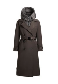 Lång brun trenchcoat med dubbelknäppta knappar och bälte i midjan. Har en avtagbar grå puffermössa för extra värme.
