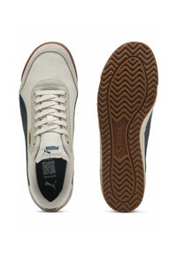 Hvide sneakers med mørkegrønne accenter, overdel i struktureret læder, gummisål med zigzag-mønster, featuring snørebånd og et lille logo.