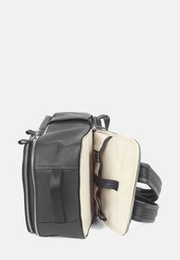 Svart läderryggsäck med silverfärgade dragkedjor, två externa fickor och en beige inredning med organiserande remmar och en enkel design.