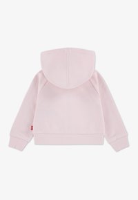 Ανοιχτό ροζ φούτερ με κουκούλα, διαθέτει ριμπ τελείωμα και μανσέτες, με καθαρό σχέδιο και απαλό ύφασμα. Χωρίς σχέδια ή μεταλλικά στοιχεία ορατά.