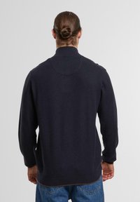 Marinenblauer Pullover aus strukturiertem Strick, mit hohem Kragen und langen Ärmeln. Enganliegend an der Taille; schlichtes, ungeschmücktes Design.