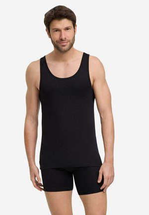 Top in cotone nero senza maniche con scollatura rotonda e spalline larghe, abbinato a pantaloni corti neri aderenti, entrambi con una texture liscia.