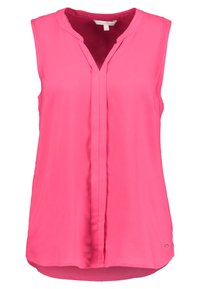 Blouse sans manches de couleur rose vif, avec un décolleté en V et une fermeture à boutons sur le devant. Tissu lisse avec un ourlet légèrement arrondi et des fentes sur les côtés.