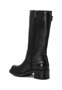 Bota negra de talle alto, fabricada en cuero sintético, con cremadora lateral, punta redondeada y un tacón de bloque estriado para mayor estabilidad.