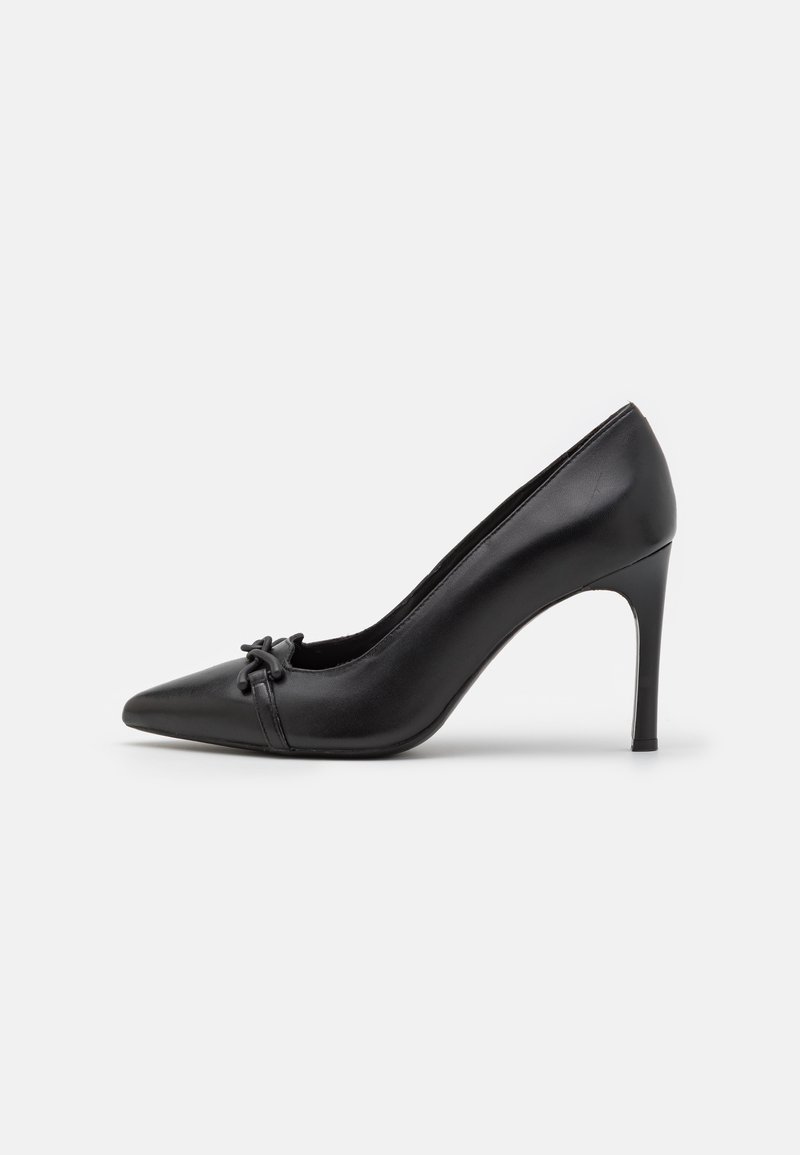 Pompe à talon aiguille pointue en cuir noir avec un talon stiletto de 7 cm et un détail de nœud décoratif à l'avant.