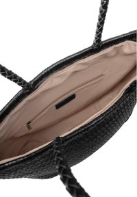 Borsa a tracolla nera intrecciata con manici intrecciati, aperta per mostrare l'interno in tessuto beige e una tasca con zip.