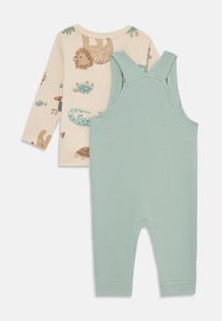 Completo per bambini in due pezzi: maglietta a maniche lunghe color crema con stampa animale e salopette a coste verdi. Le salopette presentano un design a collo rotondo e spalline.