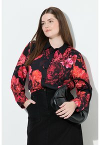 Sort blomstrete skjorte med knapper, røde og rosa blomster, lange ærmer, sammen med en sort nederdel og en sort lædertaske.