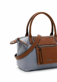 Sac à main gris avec poignées en cuir marron, poche avant et bandoulière, avec fermeture éclair et détail logo métallique sur fond blanc.