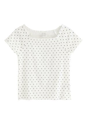 Hvid kortærmet crop top med ribstrik, lille sort hjerte mønster og bølget kant på ærmer og bund.