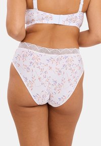Des sous-vêtements blancs à motifs en tissu doux, avec une taille bordée de dentelle et un design floral avec des feuilles aux couleurs pastel.