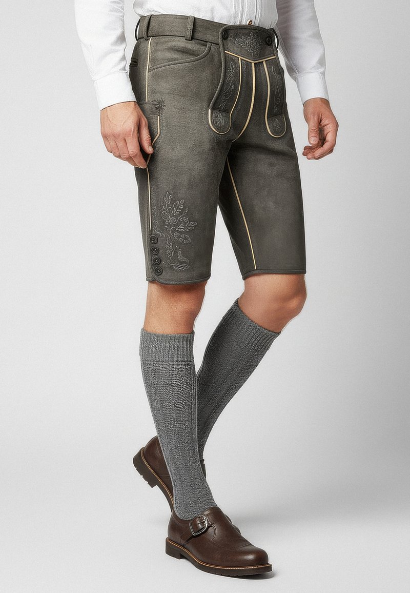 Pantaloni corti in pelle grigia con cuciture gialle e ricami floreali. Indossati con calze grigie fino al ginocchio e scarpe in pelle marrone con fibbia.