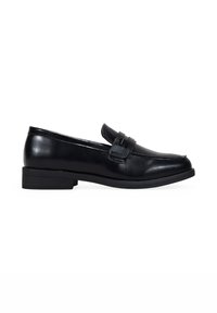 Mocasines de cuero negro con un bajo tacón de bloque, punta redondeada y correa decorativa en la parte superior. Textura suave con un brillo sutil.