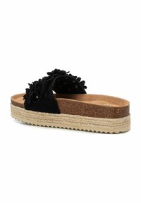 Chanclas negras con adornos florales, plantilla de corcho, ribete de yute texturizado y suela de goma serrada.