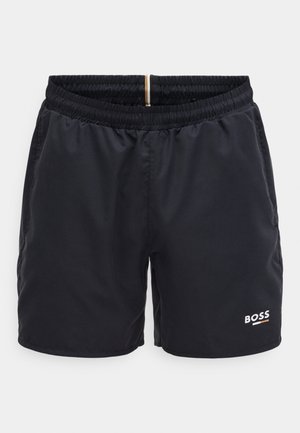 Granatowe kąpielówki z elastycznym paskiem w talii, bocznymi kieszeniami i małym biało-czerwonym logo BOSS na dolnej prawej stronie z przodu. Gładka tekstura tkaniny.