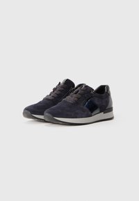 Sneakers in suede blu navy con lacci testurizzati e dettagli metallici. Presentano un pannello laterale liscio e lucido e una suola in gomma grigia.