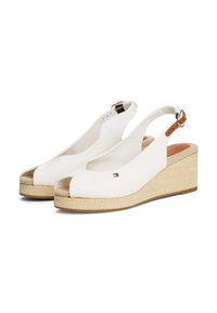 Hvite slingback kilehæler med åpen tå, laget av lerret, naturlig vevd såle og en liten logo på siden.