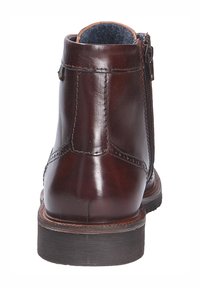 Bruine leren enkelboot met een gladde afwerking, zijrits en een stevige zwarte rubberen zool. Voorzien van brogue-details langs de naden.