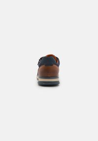 Baskets pour hommes avec une tige en maille bleu marine, un talon en cuir marron, un intérieur orange, une semelle en caoutchouc grise et des lacets minimalistes, conçues pour le confort.