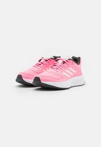 Růžové sportovní boty s prodyšným síťovaným svrškem, bílým logem se třemi pruhy, černými detaily a polstrovanou bílou podrážkou s texturovaným černým vzorkem.