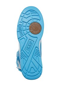 Semelle de sneaker en caoutchouc bleu avec un design texturé et des accents blancs, arborant un logo circulaire brun et des rainures pour l'adhérence.